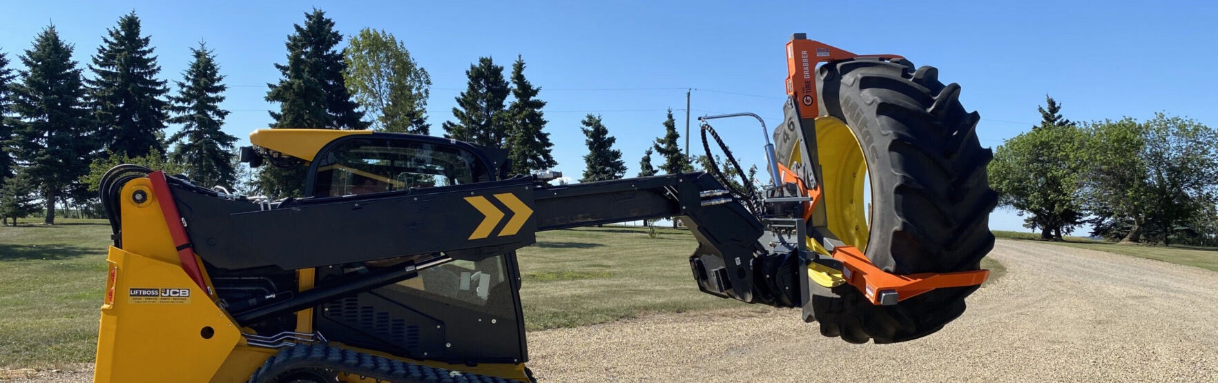 Skid Steer with TireGrabber attachment lifting a tractor tire